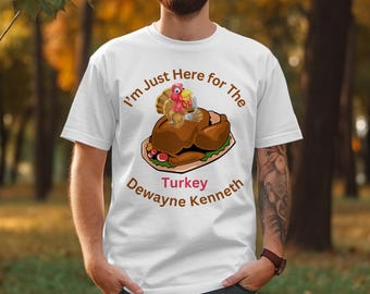 Może przedstawiać: Biała koszulka z zabawną grafiką przedstawiającą pieczonego indyka na półmisku, indyka z kreskówki i napisem "I'm Just Here for The Turkey Dewayne Kenneth."