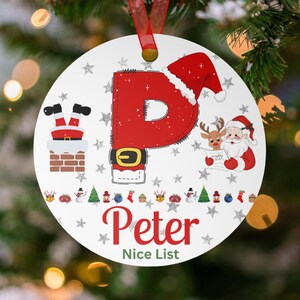 May include: A round Christmas ornament with a red ribbon. The ornament features a large red letter "P" with a Santa hat, a Santa Claus illustration, and the name "Peter" with "Nice List" text. Decorative stars and holiday icons surround the design.
