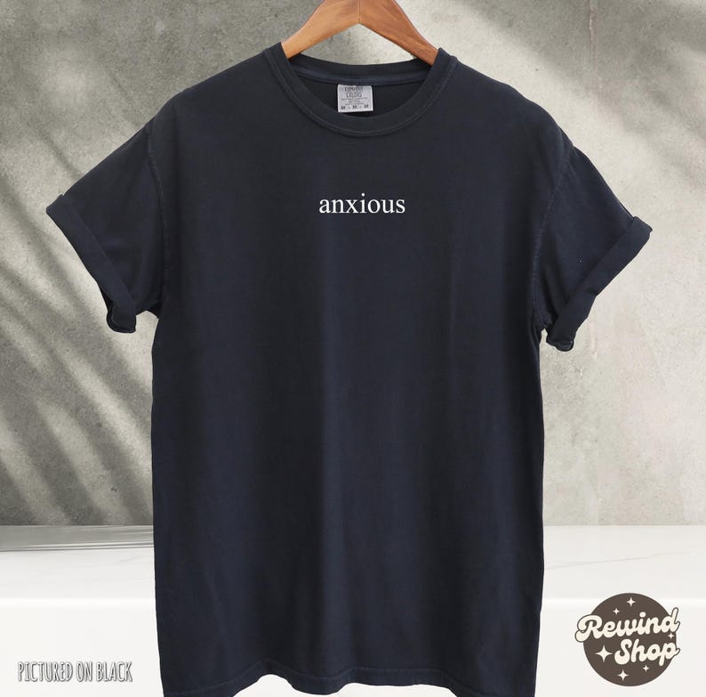 May include: A black t-shirt with the word "anxious" printed in white on the front.