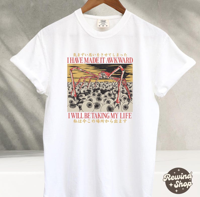 May include: White t-shirt with a graphic design featuring a red and yellow spider-like creature with multiple eyes. The text "I HAVE MADE IT AWKWARD" and "I WILL BE TAKING MY LIFE" are printed above and below the graphic, respectively.