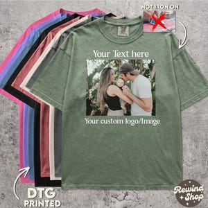 May include: A selection of oversized t-shirts in various colors, including pink, blue, black, and green. The green shirt features a family photo with the text "Your Text here" and "Your custom logo/Image". The shirts are labeled "DTG PRINTED".