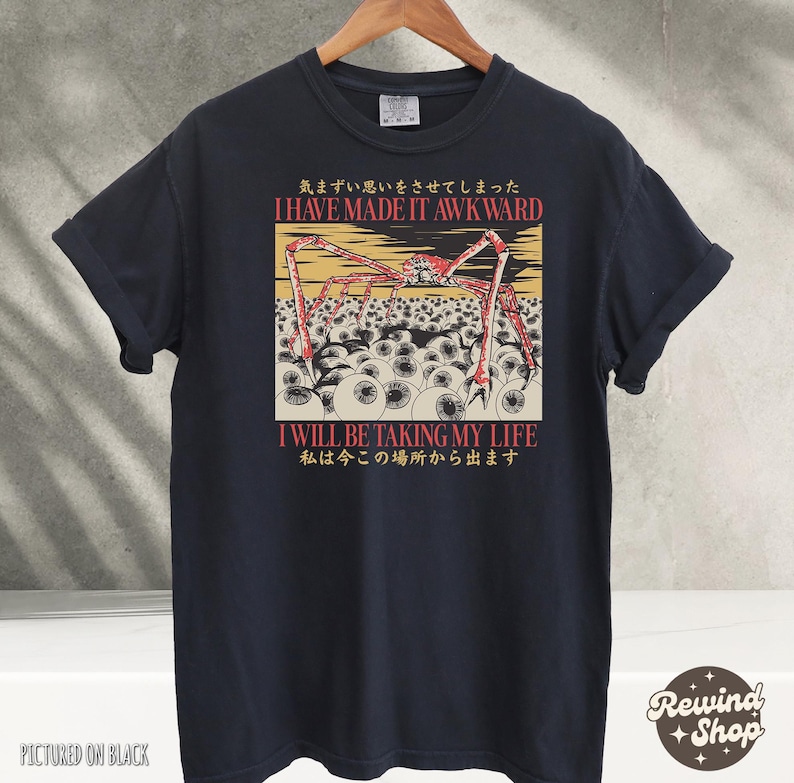 May include: Black t-shirt with a graphic design featuring a red spider-like creature with long legs, set against a background of eyeballs. The shirt includes the text "I HAVE MADE IT AWKWARD" and "I WILL BE TAKING MY LIFE".