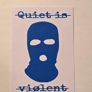 Peut inclure: Une carte blanche avec un dessin de cagoule bleu. Les mots "Quiet is" et "violent" sont imprimés en bleu au-dessus et en dessous du dessin, respectivement. Le texte est barré d'un trait bleu.