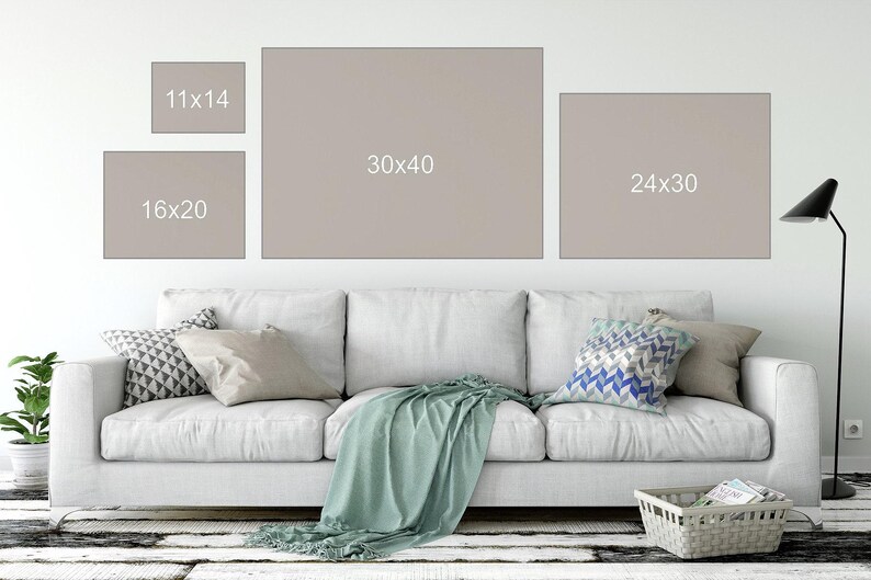 a living room with a couch and samples of different print sizes on the wall