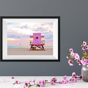 a desk with a photo of a pink lifeguard stand on miami beach at sunrise above it. photography by catch a star fine art.