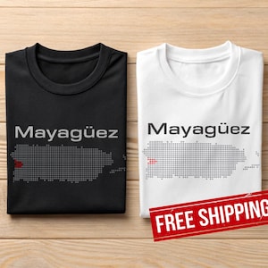May include: Two t-shirts, one black and one white, each with the word "Mayagüez" above a dotted outline of Puerto Rico. The black shirt has a red dot on the map. The white shirt has a red dot on the map.