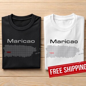 May include: Two t-shirts, one black and one white, with the word "Maricao" above a dotted outline of Puerto Rico. A red line highlights a section of the island. The white shirt has a red "FREE SHIPPING" sticker.