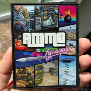 May include: A rectangular patch with the word "AMMO" in white block letters. The patch features various military-themed illustrations, including a bomb, missiles, and soldiers. The text "Iyaayas" is written in a cursive font.