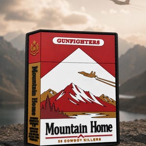 Può includere: Una toppa rettangolare con un design rosso e bianco raffigurante un paesaggio montano, un aereo da caccia e il testo GUNFIGHTERS, Mountain Home e 20 COWBOY KILLERS. La toppa presenta un bordo nero e un emblema dorato sul lato.