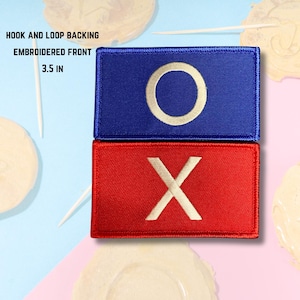 May include: Embroidered patches with a blue rectangle and a white "O", and a red rectangle with a white "X". The patches have a hook and loop backing and are 8.89 cm in size.