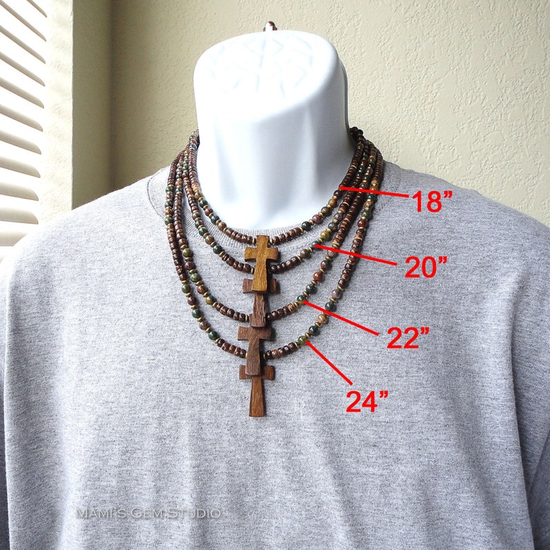 May include: A multi-strand necklace with wooden beads and cross pendants. The necklace is shown on a model and is available in four lengths: 18 inches, 20 inches, 22 inches, and 24 inches.