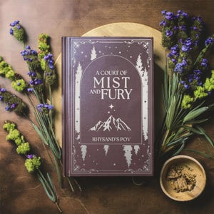 May include: A burgundy hardcover book with a silver title, "A Court of Mist and Fury, Rhysand's POV". The book is surrounded by sprigs of lavender and a small bowl of brown material.