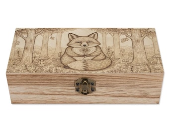 May include: Wooden box with a detailed engraved forest scene and a fox holding a flower. The box has a hinged lid and a metal clasp. The artwork is in shades of brown and beige.