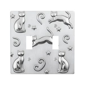May include: A silver-colored light switch cover with a brushed metal finish. The cover features embossed cat silhouettes, stars, and decorative swirls. The design includes two switch openings.