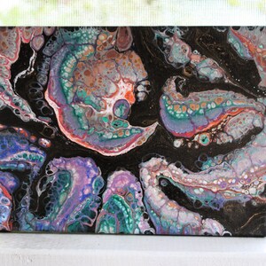 Peut inclure: Peinture abstraite coulée à l'acrylique sur toile. L'œuvre présente un fond sombre avec des motifs tourbillonnants dans des tons de sarcelle, de violet, d'orange et de blanc. Le style d'art fluide crée un aspect unique et texturé, adapté à la décoration intérieure.