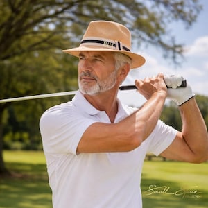 Peut inclure: Un chapeau fedora en paille beige avec une bande rayée bleu marine et blanche, un polo blanc à manches courtes et un pantalon gris clair avec une ceinture en tissu assortie. Le texte Small Space COLLECTIONS est visible à droite.