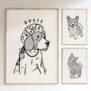 May include: Three framed illustrations of pets. The first illustration is of a dog wearing a spotted hat with the name "Rosie" written above. The second illustration is of a dog with the name "Ollie" written above. The third illustration is of a cat with the name "Sadie" written above.