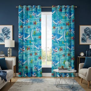 May include: Blue and turquoise window curtains featuring a repeating pattern of cartoon sharks and colourful fish. The curtains are hanging in front of a window, adding a playful touch to the room's decor.