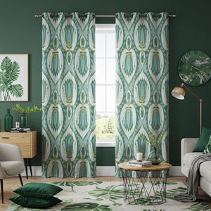 May include: Two matching teal and white patterned curtains hang in front of a window. The curtains have a repeating floral design with gold accents. The room has a green wall, a green clock, and a green rug with a leaf pattern.