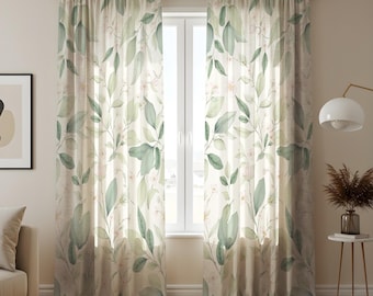 May include: Two sheer window curtains with a watercolor-style botanical design. The curtains feature a pattern of green leaves and small pink flowers on a cream-colored background. The curtains are hanging in front of a window.