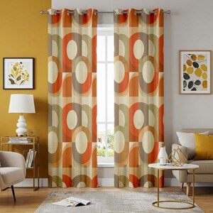 May include: Two patterned window curtains with a retro design. The curtains display a repeating geometric pattern of orange, brown, and cream shapes. The curtains hang in front of a window, and the room has a mid-century modern style.