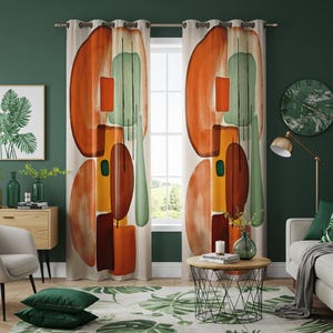 Op de afbeelding: Een paar oranje, bruine, groene en gele gordijnen met een abstract geometrisch patroon en oogjes, hangend in een woonkamer met een groene muur, een salontafel en een bank.
