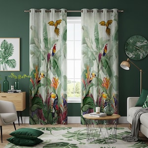 Può includere: Un paio di tende colorate chiare con un design tropicale con pappagalli, tucani e un'esuberante vegetazione verde. Le tende sono appese davanti a una finestra, creando un'estetica vibrante e ispirata alla natura. La stanza è decorata con decorazioni abbinate.