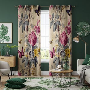 May include: A pair of cream-coloured curtains with a floral print featuring pink roses, butterflies, and green leaves. The curtains have a subtle sheen and are hung on a silver curtain rod.