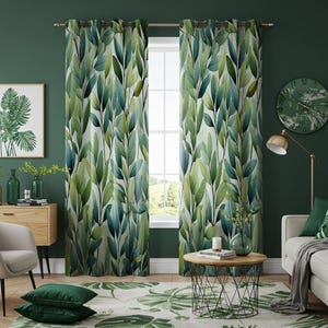 Könnte beinhalten: Ein Paar grüne und weiße gemusterte Vorhänge mit einem Aquarell-Blattdesign. Die Vorhänge sind an einem Fenster mit Blick auf einen grünen Rasen und Bäume aufgehängt.