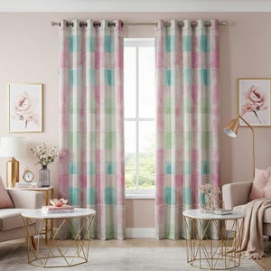 Può includere: Un paio di tende rosa e verdi con occhielli in alto sono appese in un soggiorno con una parete rosa. Le tende hanno un design ad acquerello con quadrati rosa, verdi e blu.