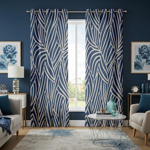 May include: Navy blue curtains with a cream-colored leaf pattern. The curtains hang in front of a window, and the room is decorated with matching blue accents, including artwork and throw pillows. The curtains are a focal point in a well-lit living space.