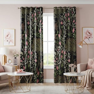 Op de afbeelding: Een paar zwarte gordijnen met een bloemenpatroon met roze bloemen en groene bladeren. De gordijnen hangen aan een raam met witte bekleding en uitzicht op een groene gazon.