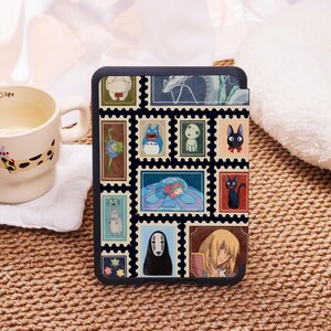 May include: Black tablet case with a collage of colourful postage stamp designs featuring anime characters. The stamps are arranged in a grid pattern, showcasing various illustrations. The case has a dark border and a smooth finish.