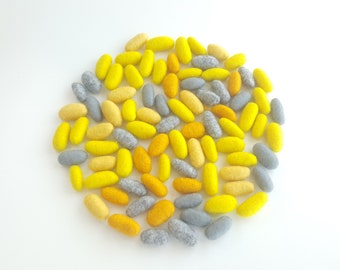 Tinker tray play. Felted wool beads, felt pebbles. Yellow and gray shades. Wool stones, textile beads, felt nugget, tinker tray filling