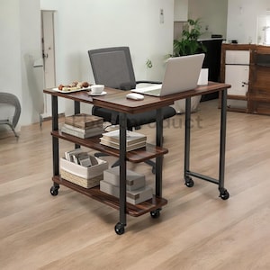 May include: A brown wooden L-shaped desk with black metal legs and wheels. The desk has three shelves for storage. A laptop computer, a wireless mouse, and a cup are on the desk.