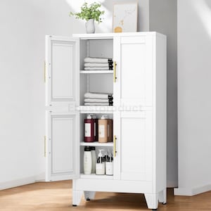 May include: A white storage cabinet with two doors, partially open. The cabinet has shelves holding folded white towels and various bottles of toiletries. Gold-colored handles and hinges add a touch of elegance. A vase of greenery sits on top.