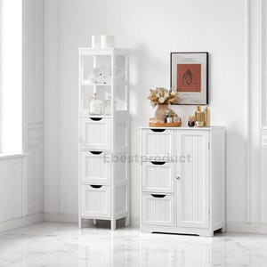 May include: Two white wooden bathroom storage cabinets. One is a tall, narrow cabinet with open shelves and drawers. The other is a shorter cabinet with drawers and a door. Both are in a bright, clean bathroom setting.
