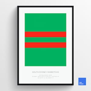 May include: A framed print of the South Sydney Rabbitohs rugby league team logo. The logo features three red stripes on a green background. The text "South Sydney Rabbitohs" is printed below the logo, along with the team's founding date, location, and coordinates.