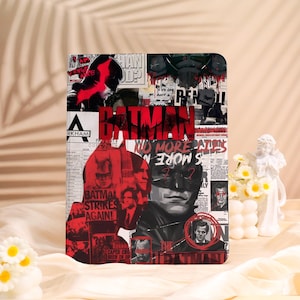 May include: A rectangular Batman-themed item with a collage design in red, black, and white. The design includes the word "Batman" and the text "Batman Strikes Again!" along with various images and text fragments.