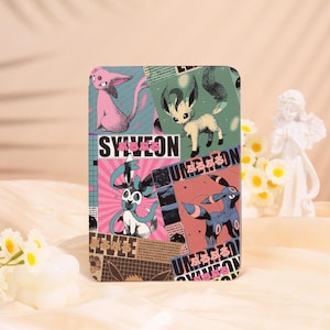 May include: Rectangular decorative panel with cartoon characters in pink, blue, and green. The panel has the word "SYLVEON" in white, with Japanese text. The background includes newspaper-style graphics.