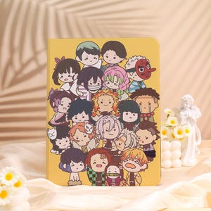 May include: Yellow tablet case featuring a colorful cartoon illustration of multiple anime characters. The case has a smooth finish and a rectangular shape. The characters have various hair colors and expressions, creating a playful and vibrant design.