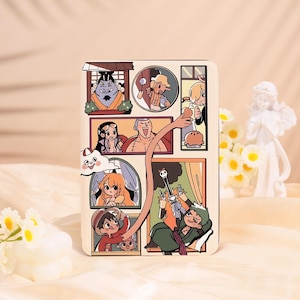 May include: A beige phone case featuring a colorful cartoon collage of characters. The design includes various panels with different characters and scenes, with a long arm reaching across the panels. The overall style is reminiscent of a comic book.