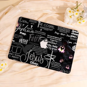 Peut inclure: Housse d'ordinateur portable noire avec texte religieux et motifs floraux. Le design comprend les mots "Jésus", "Foi" et des versets bibliques en blanc sur fond noir. Comprend un motif floral avec des orchidées violettes et roses.