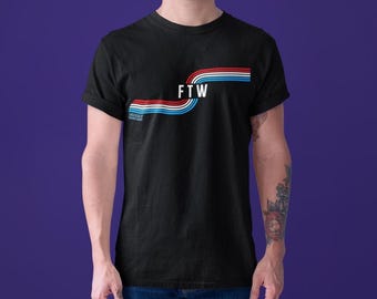 Puede incluir: Camiseta negra con un diseño a rayas rojo, blanco y azul y el texto "FTW" en blanco.