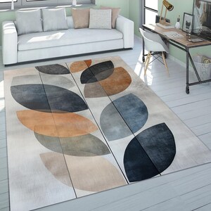 May include: Abstract area rug with a geometric pattern of overlapping circles in shades of brown, blue, and gray on a white background.
