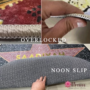 Peut inclure: Un tapis de sol rectangulaire pr&eacute;sentant un motif d'&eacute;toile rouge et or avec le nom SAADIYAH imprim&eacute; en lettres dor&eacute;es. Le tapis poss&egrave;de des bords surjet&eacute;s et un envers noir antid&eacute;rapant textur&eacute;, rappelant le style d'une &eacute;toile du Walk of Fame.