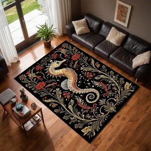 May include: Black rectangular rug with a seahorse motif. The seahorse is in gold, orange, and red hues. The rug is adorned with gold and red floral and leaf patterns. The rug is placed on a wooden floor.