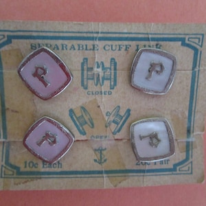 May include: A vintage card with four cuff links featuring a pink and white enamel design with a silver letter 'P' on each. The card reads 'Separable Cuff Links' and '10c Each' and '20c Pair'.