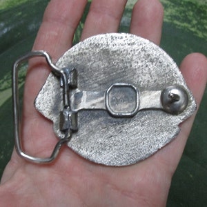 Puede incluir: Hebilla de cintur&oacute;n plateada con un dise&ntilde;o detallado. La parte posterior de la hebilla tiene un bucle de metal y un peque&ntilde;o bot&oacute;n de metal. La hebilla est&aacute; marcada con "Donner".