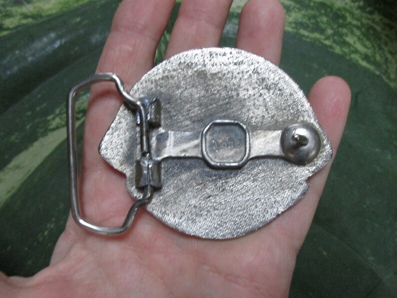 Puede incluir: Hebilla de cintur&oacute;n plateada con un dise&ntilde;o detallado. La parte posterior de la hebilla tiene un bucle de metal y un peque&ntilde;o bot&oacute;n de metal. La hebilla est&aacute; marcada con "Donner".